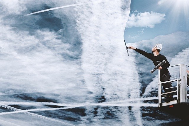 EIn Mann putzt eine große Glasfläche